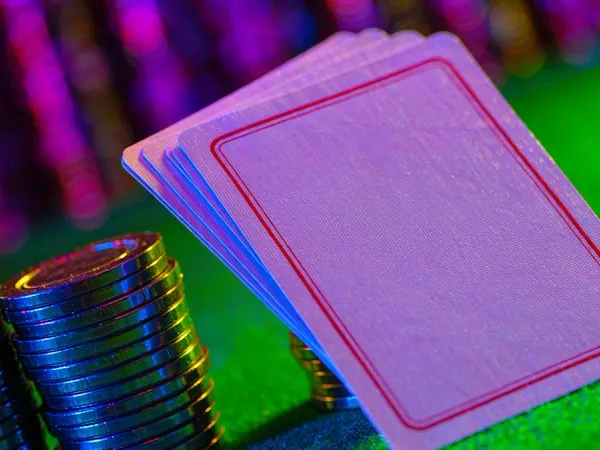 m66 Face-down playing cards beside colourful casino chips